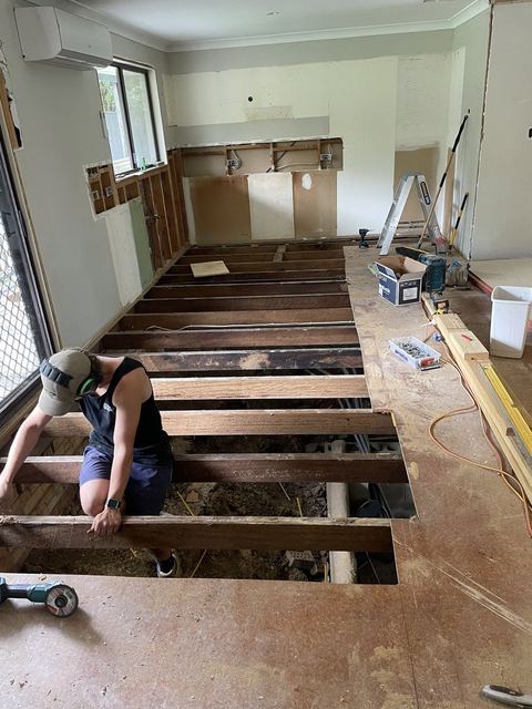 Carpenter replacing the timber floor frame in a room