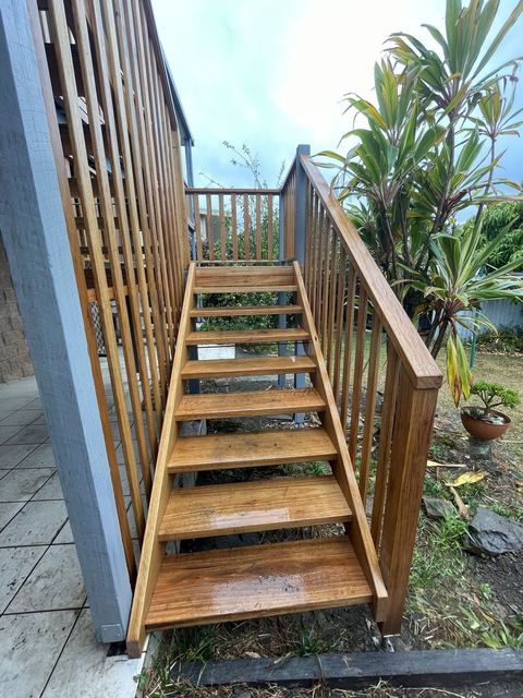 Finished timber stairs with a timber balustrade leading down to the yard