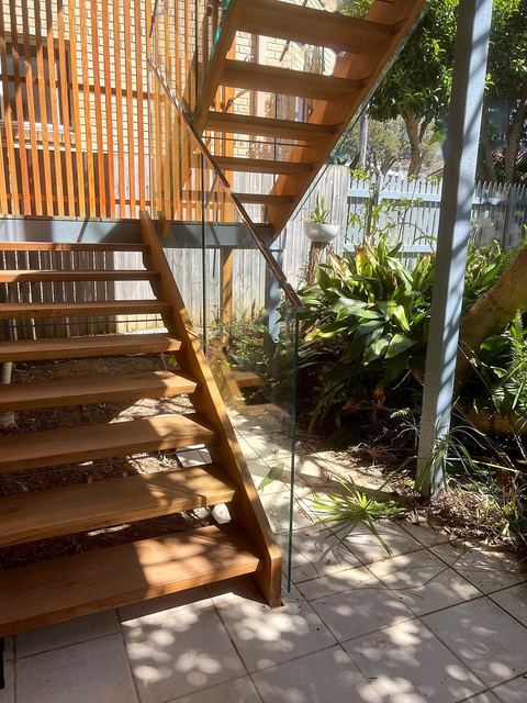 Open hardwood stairs with a frameless glass balustrade
