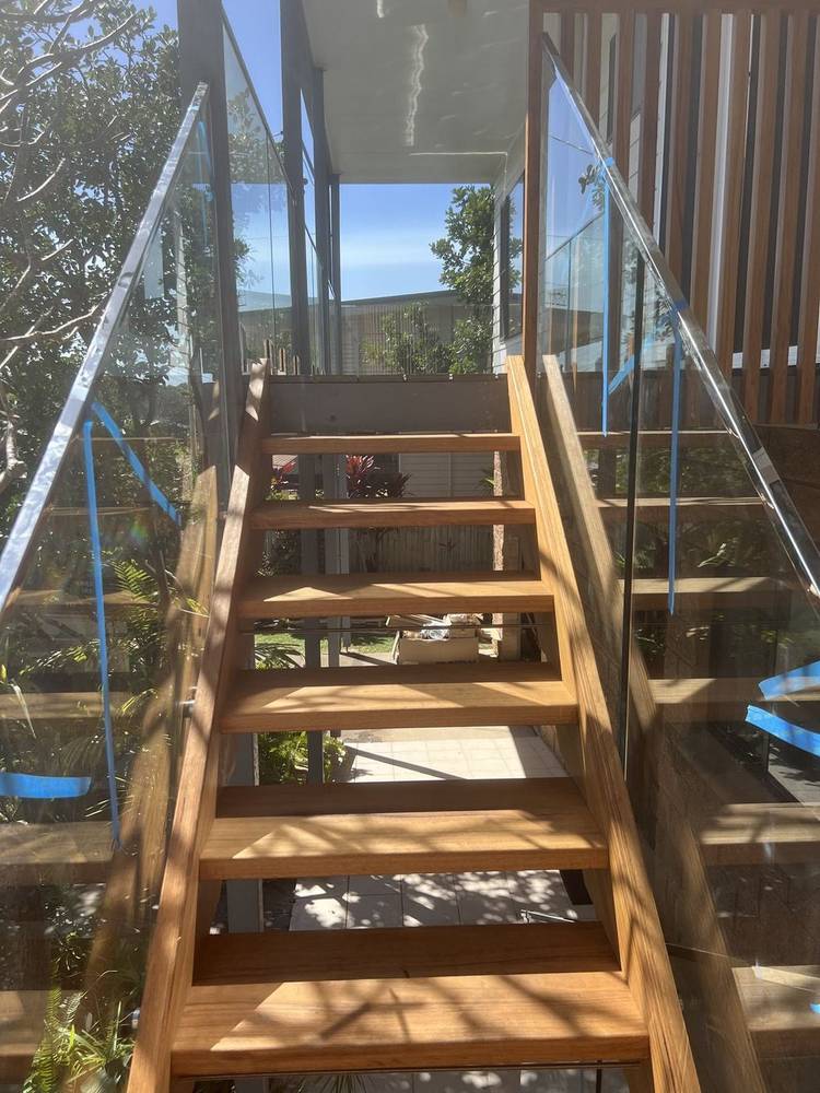 Open-tread timber stairs with glass balustrade panels