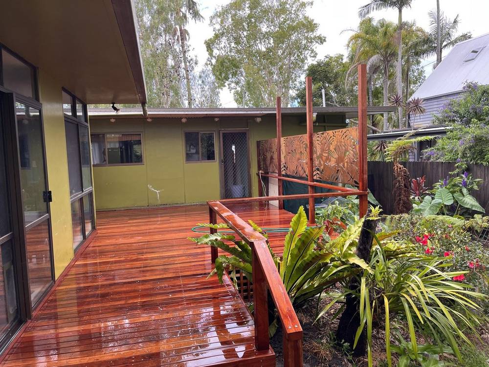 Freshly oiled hardwood deck and steps beside a tropical garden
